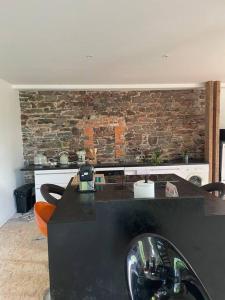 a kitchen with a black counter and a brick wall at La Maison Cahour in Redon +19 photos
