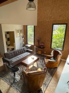 a living room with a leather couch and chairs at La Maison Cahour in Redon