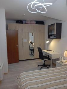 a bedroom with a desk and a chair in a room at Mountainview Apartment Ski, Spa & Thermal in Bansko