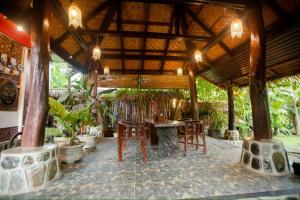 eine Außenterrasse mit einem Tisch, Stühlen und Pflanzen in der Unterkunft Green Travelodge Bukit Lawang in Bukit Lawang