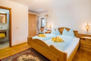 a bedroom with a large bed with yellow pillows on it at Pension Rainhof in Kitzbühel