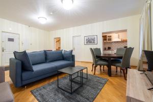 a living room with a blue couch and a table at Old Town - Demini Apartment in Tallinn