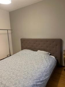 - une chambre avec un lit et une couverture grise dans l'établissement L’appartement du père Noël, à Genève