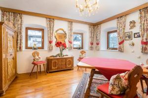 a dining room with a red table and chairs at Pension Rainhof in Kitzbühel