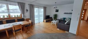 a living room with a table and a living room with a couch at Ferienwohnung Widmann in Jochberg