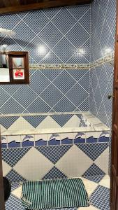 Cette chambre dispose de lits et de murs carrelés bleus et blancs. dans l'établissement Hostel das fadas, à Parati