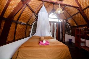 a bedroom with a bed with a dress on it at Green Travelodge Bukit Lawang in Bukit Lawang
