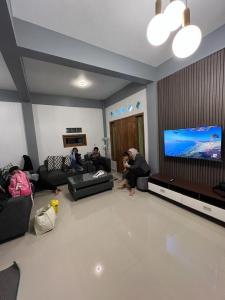 a group of people sitting in a living room watching tv at AAA, Ngadisari Villa, Aesthetic Villa Bromo, Managed by Triple A Tour in Ngadisari