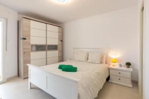 a bedroom with a white bed with a green pillow on it at Seafront Luxury Penthouse Torrox Costa in Torrox +63 photos