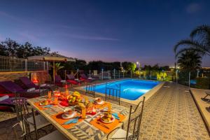 a table with food on it next to a swimming pool at Villa Culebra by Algarve Vacation in Albufeira +42 photos