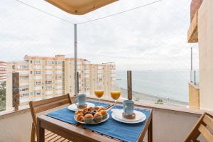 a table with two glasses of wine and food on a balcony at Seafront Luxury Penthouse Torrox Costa in Torrox