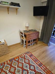 Habitación con mesa, silla y alfombra. en Alpazur-studio départ pistes, en Péone