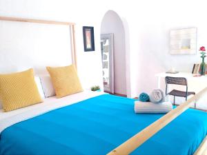een slaapkamer met een bed met blauwe lakens en een tafel bij Holy House in Santa Brígida