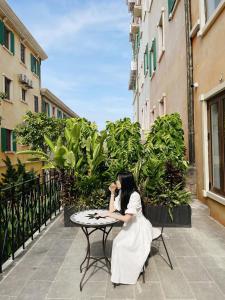 a woman sitting at a table in front at Mellon OASIS Phu Quoc in Phu Quoc