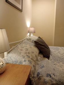 a bedroom with a bed and a table with a lamp at Bwthyn Bach (Tiny Cottage) in Wrexham