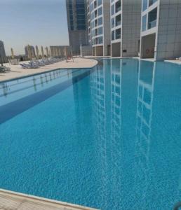 a large swimming pool with blue water in a building at Dream Beach View in Ajman 