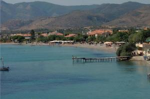 a beach with a pier in the middle of the water at Superior Seaview Apartment in Antirrio