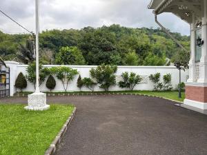 Sumedangにあるdaily villa 44b sumedangの庭の白柵と木々を用いた私道