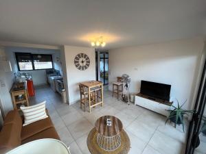 ein Wohnzimmer mit einem Sofa und einem Tisch in der Unterkunft L’appartement du bonheur in Issoire