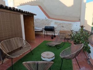 eine Terrasse mit Stühlen, einem Tisch und einem Grill in der Unterkunft Petra apartments -Old City with terrace and barbecue- in Tarragona