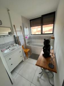 a small bathroom with a sink and a tub at L’appartement du bonheur in Issoire