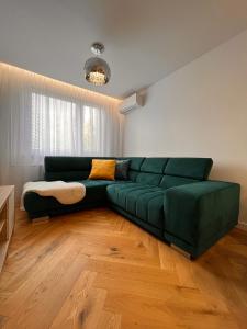 - un canapé vert dans le salon dans l'établissement Modern apartment in Košice, à Košice