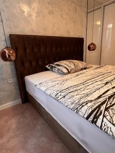 - un lit avec une tête de lit marron et un oreiller dans l'établissement Modern apartment in Košice, à Košice