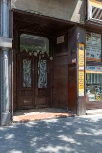 een ingang naar een winkel met een grote houten deur bij Spacious Bajcsy Residence in the heart of Budapest in Boedapest
