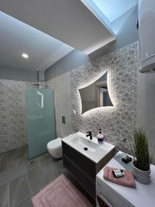 La salle de bains est pourvue d'un lavabo, de toilettes et d'un miroir. dans l'établissement Black Eagle Apartment, à Dráma