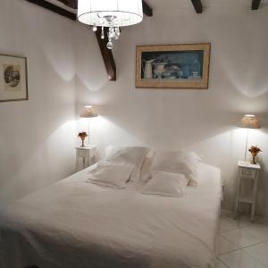um quarto com uma cama branca com duas mesas de cabeceira em Gîte Rozies Dunes 6 p em Dunes