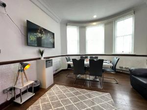 uma sala de estar com mesa e cadeiras em Spacious City Haven Chic & Modern em Birmingham