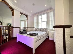 um quarto com uma cama grande e iluminação roxa em Spacious City Haven Chic & Modern em Birmingham