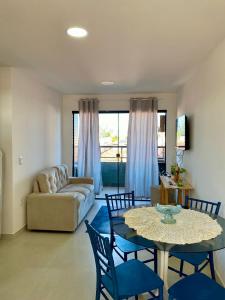 a living room with a table and chairs and a couch at Apartamento Completo Praia do Poço - Cabedelo - PB in Cabedelo
