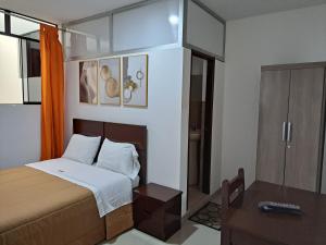 a small bedroom with a bed and a table at TintayaHotel in Chachapoyas