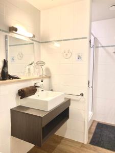 een witte badkamer met een wastafel en een douche bij Charmehotel Kruishof in Oostende