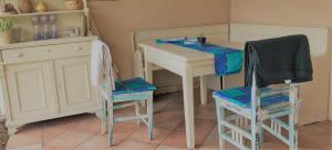 a kitchen with a table and two chairs and a desk at Kis Szárcsa Vendégház in Gárdony