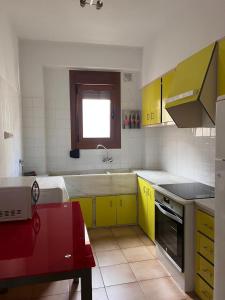 een keuken met gele en witte kasten en een raam bij Apartamento en el Parque in Ontinyent