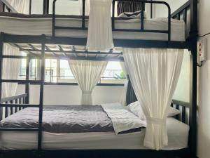 a bedroom with two bunk beds with a window at Backpack Hostel in Chiang Rai