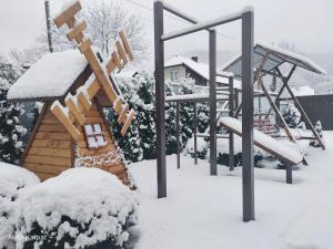 a playground covered in snow with a slide at Нота Карпат in Skole