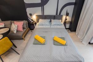 een slaapkamer met een groot bed met twee gele kussens bij Urban Jungle apartament Delta in Białystok