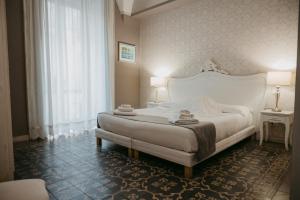 a bedroom with a large white bed and a window at La Casa di Alma Luxury rooms in Catania