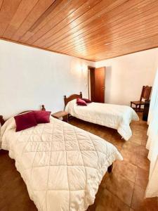 a bedroom with two beds in a room at La Rosada Casa de Campo in General Las Heras