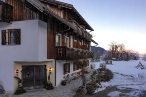 a building with a door and a snow covered yard at Schullerhof in Hermagor