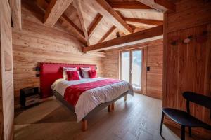1 dormitorio con 1 cama roja en una cabaña de madera en Chalet Charme & SPA - Serre Chevalier 1500, en Le Monêtier-les-Bains