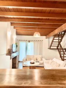 ein Wohnzimmer mit einer weißen Couch und einer Treppe in der Unterkunft La Rosada Casa de Campo in General Las Heras
