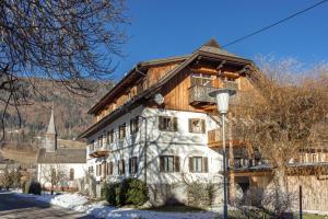 ein großes Gebäude mit einem Holzdach in der Unterkunft Schullerhof in Hermagor