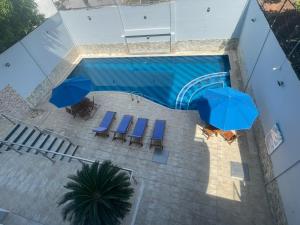 an overhead view of a swimming pool with chairs and umbrellas at Hotel Altamar Cartagena in Cartagena de Indias