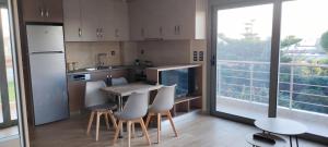 a kitchen with a table and chairs and a large window at Antirrio apartments - Superior Bridge Apartment in Antirrio +10 photos