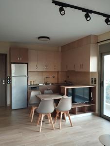 a kitchen with a table and chairs and a refrigerator at Superior Bridge Apartment in Antirrio