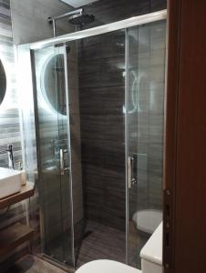 a shower with a glass door in a bathroom at Superior Bridge Apartment in Antirrio